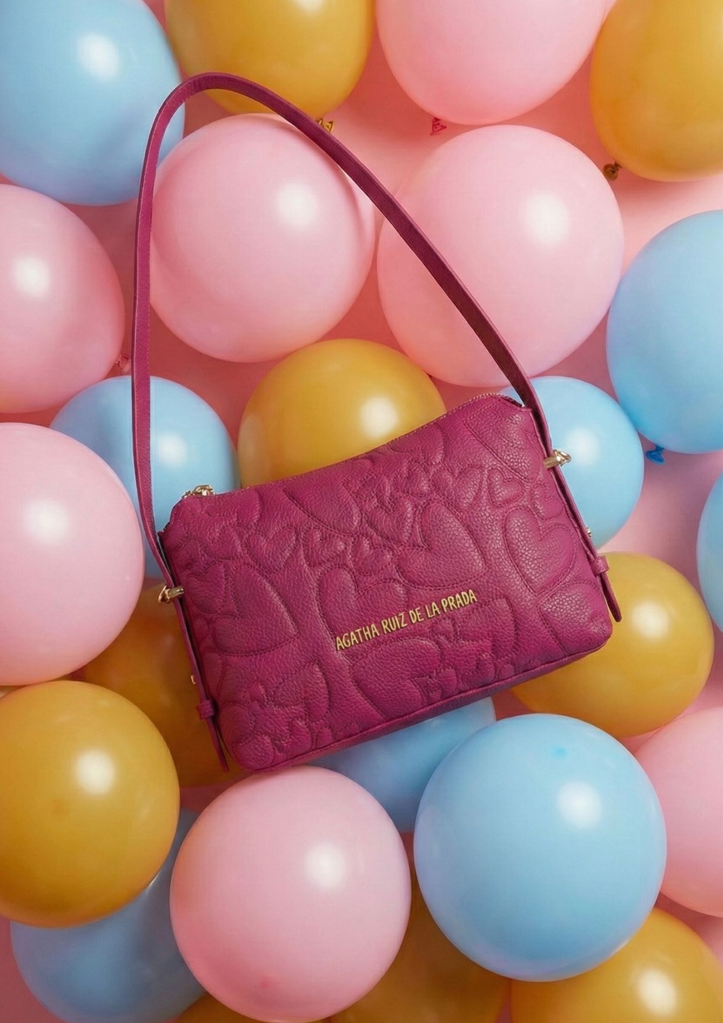 Complemento de moda con bordado de corazones y diseño exclusivo. Bolso baguette fucsia con asa regulable y cierre de cremallera