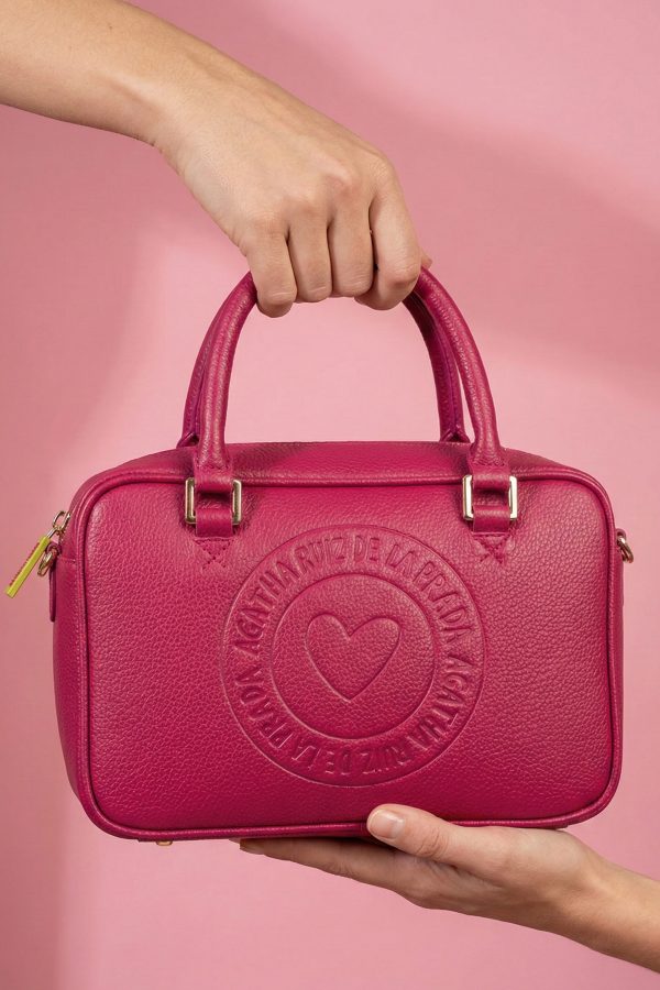 Mini bolso fucsia con formato rectangular y logo frontal.