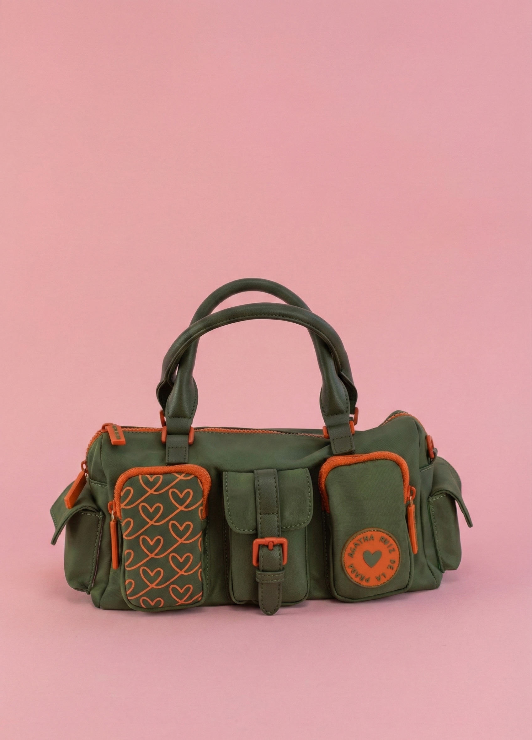 Detalle del bolsillo con estampado de corazones en contraste. Bowling verde con contrastes en naranja y bolsillos exteriores.