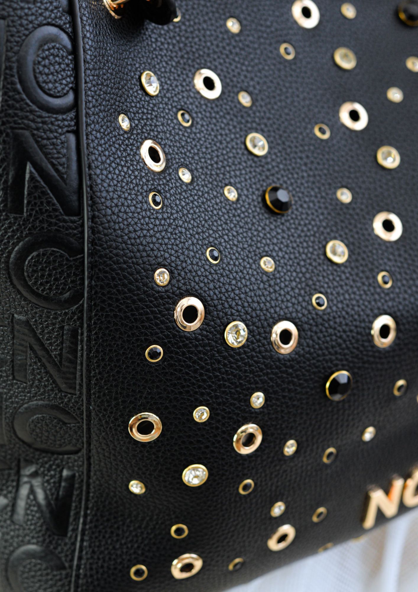 Detalle de pedrería frontal en bolso negro NOCO Detalle de pedrería frontal en bolso NOCO negro