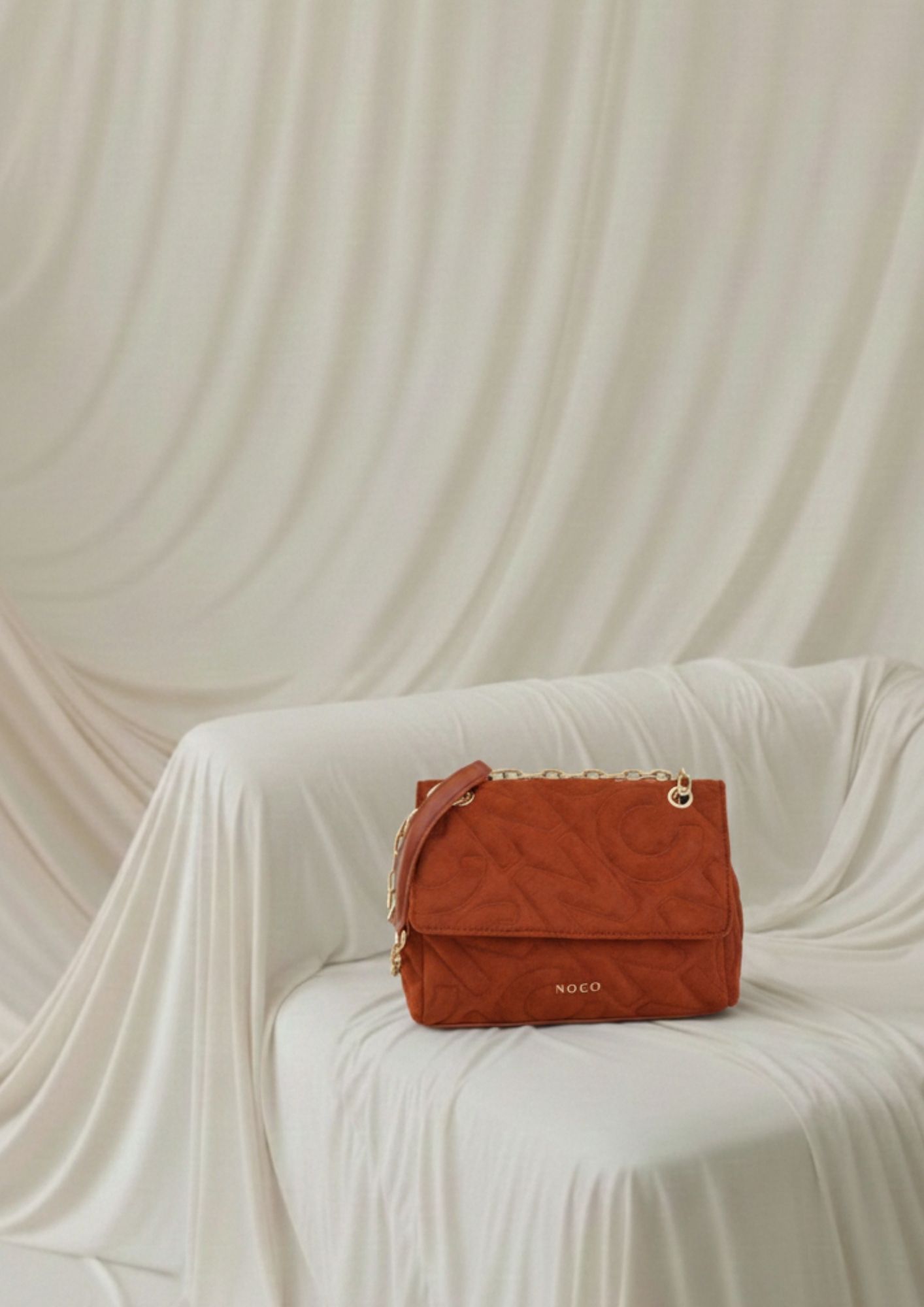 Bolso con tapa y cadena metálica NOCO Bandolera solapa antelina para mujer caldera