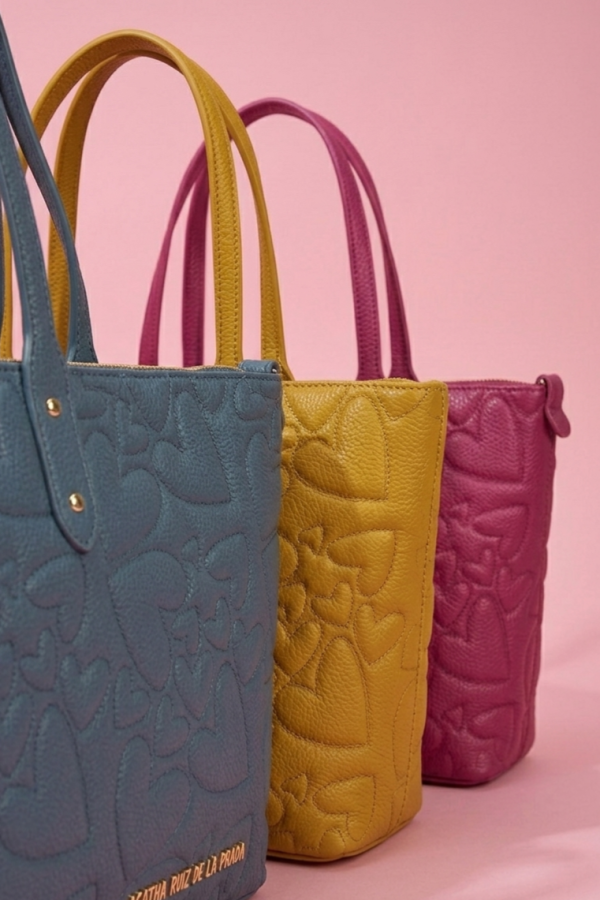 Detalle del logo metálico dorado del bolso shopper.