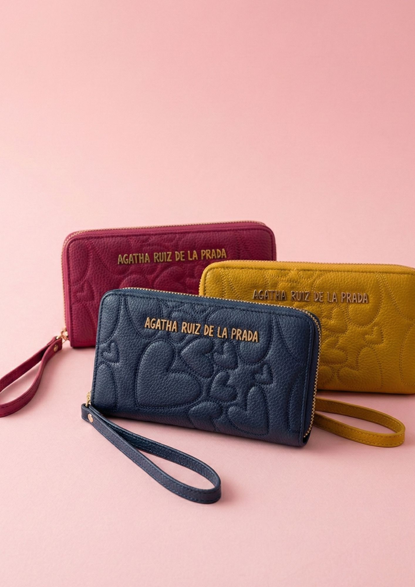 Complemento Agatha Ruiz de la Prada disponible en azul denim, fucsia y mostaza. Billetero elegante con cierre perimetral de cremallera.