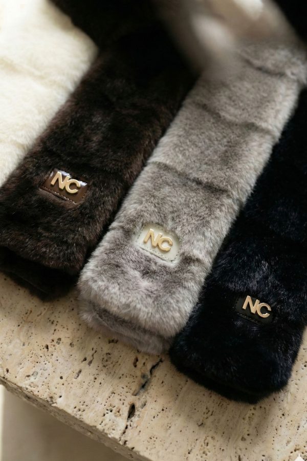 Detalle del logo NC en chal de pelo laminado