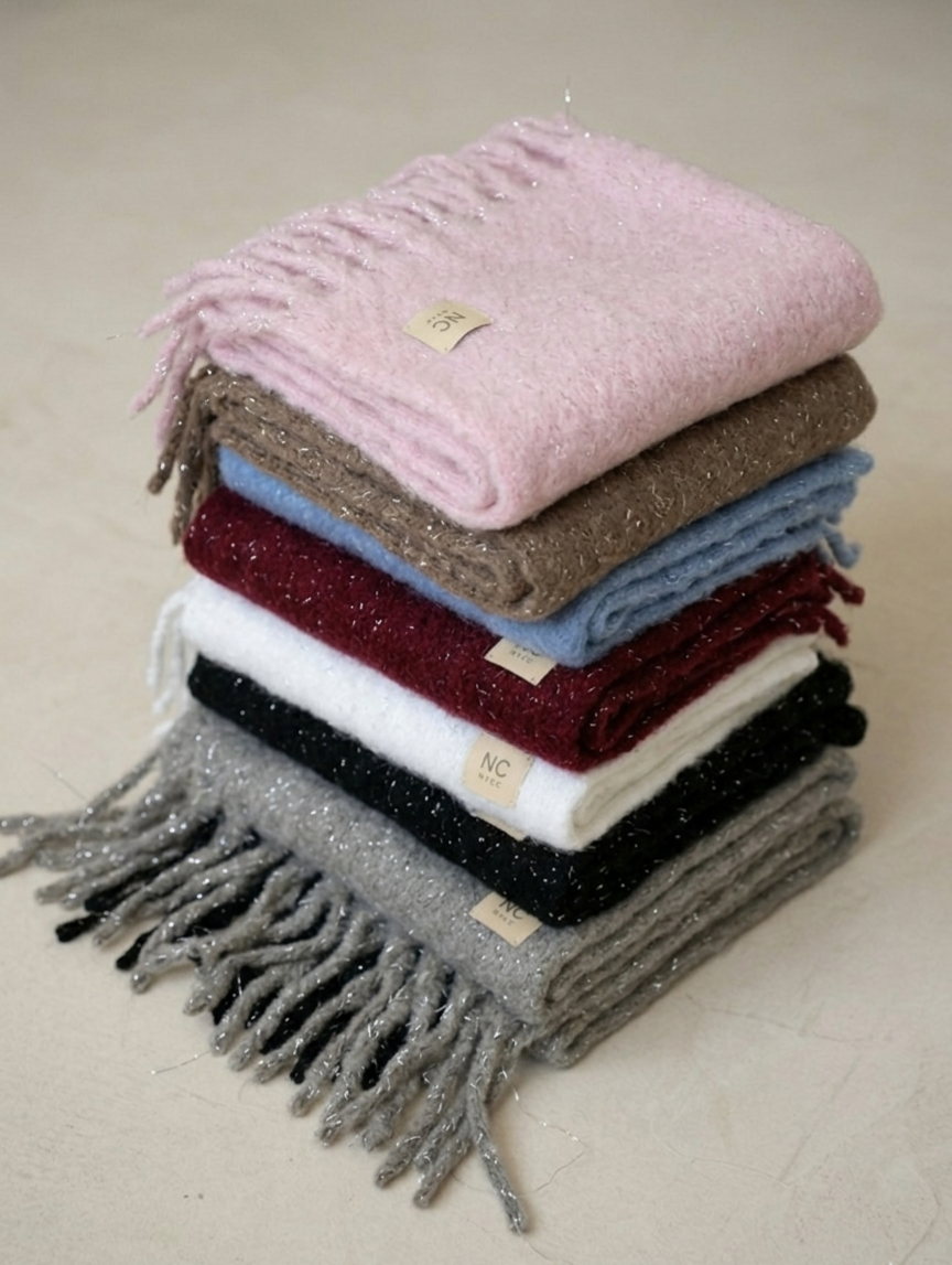 Bufanda de invierno con flecos anchos y diseño elegante. Detalle del hilo de lúrex plateado de la bufanda manta Noco.